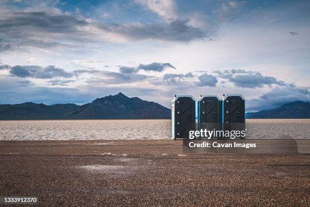 three portable toilets stand next to the bonneville salt flats, utah - mietklo stock-fotos und bilder