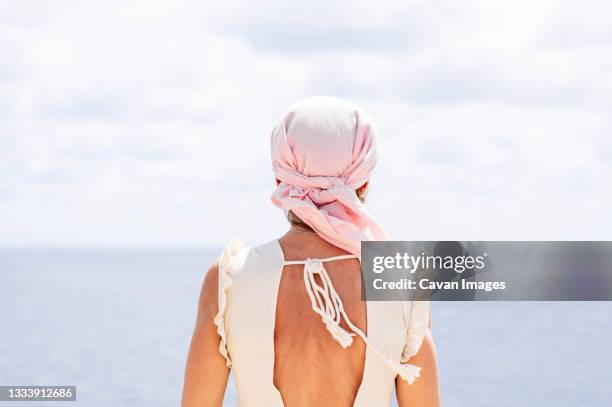 woman with pink headscarf, has cancer - shaved head ストックフォトと画像