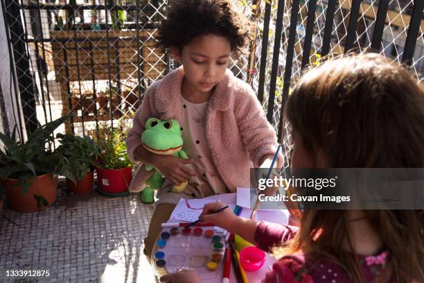 two girls sitting on the balcony sharing time by painting, copy space - buenos aires art stock pictures, royalty-free photos & images