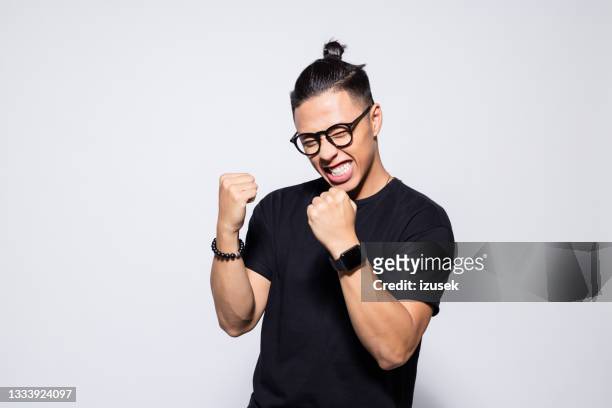 excited asian young man in black clothes - excitement stock pictures, royalty-free photos & images