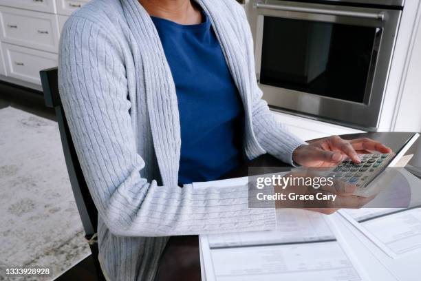 woman reviews financial documents - irc imagens e fotografias de stock