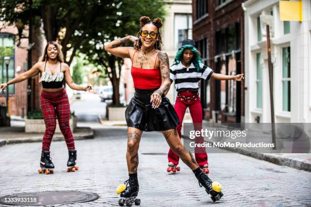young women rollerskating in urban area - hip hop fotografías e imágenes de stock