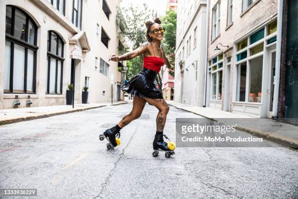 young woman rollerskating in urban area - leather training shoes stock-fotos und bilder