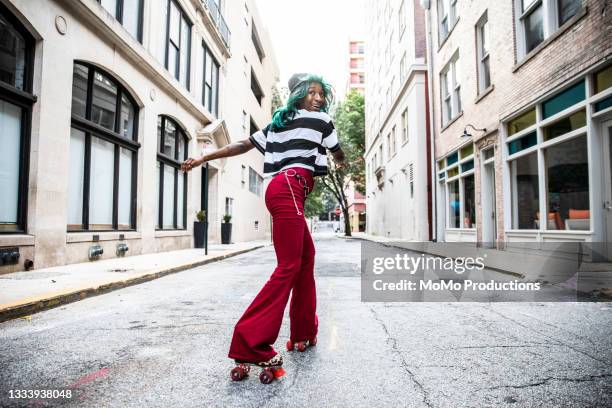 young woman rollerskating in urban area - roller-skating stock pictures, royalty-free photos & images