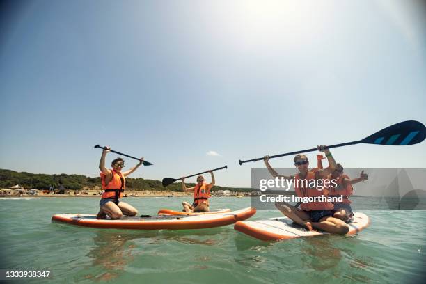 family enjoying paddle boarding on sup - young teen girl beach stock pictures, royalty-free photos & images