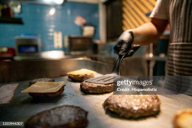 primer plano de un chef preparando hamburguesas en un restaurante - comedor edificio de hostelería fotografías e imágenes de stock