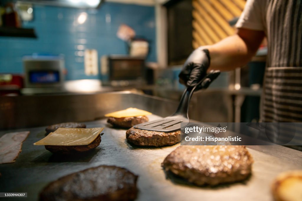 Close-up em um chef preparando hambúrgueres em um restaurante