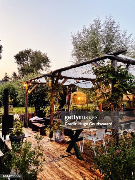 decorated table in summer setting. garden party. summer garden patio terrace. rotan light. ibiza vibe. - terraced field stockfoto's en -beelden
