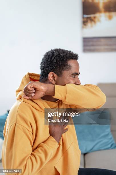 adult man coughing or sneezing into elbow - covering cough stock pictures, royalty-free photos & images