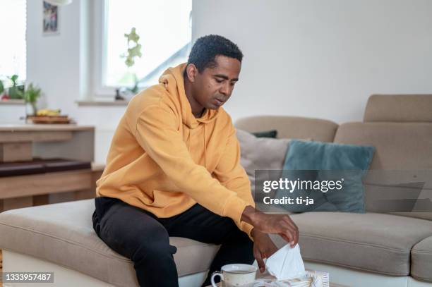 adult man taking a tissue out of a box - tissue box stockfoto's en -beelden