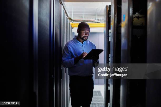 サーバールームで作業中にデジタルタブレットを使用した男性エンジニアのショット - server room ストックフォトと画像