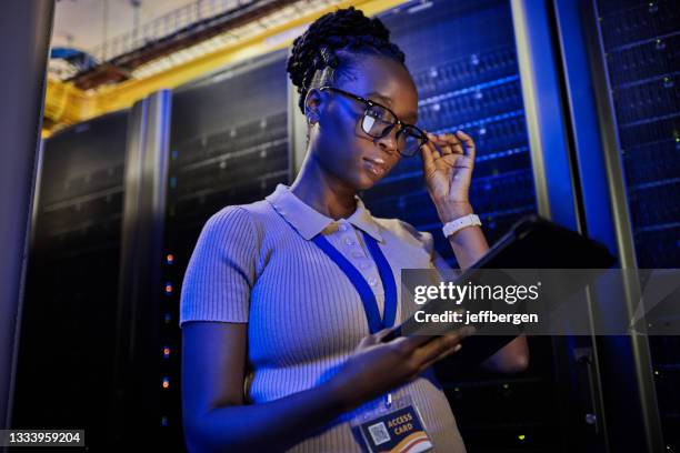 aufnahme einer jungen ingenieurin mit einem digitalen tablet bei der arbeit in einem serverraum - bildtechnik stock-fotos und bilder