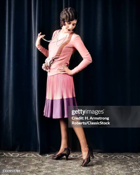 1920s Flapper Woman Posing Hand On Hip Holding String Of Pearls Stretching Leg Checking Hosiery Seams .