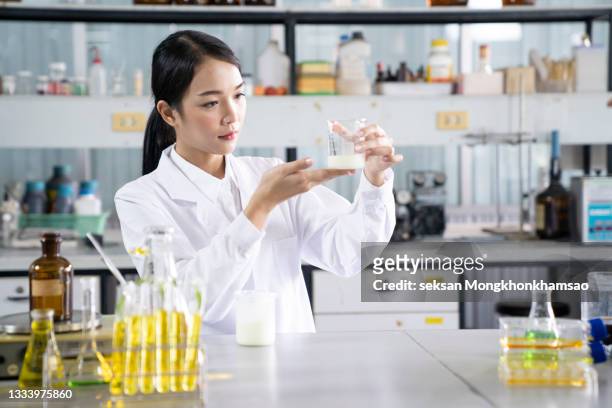 the scientist,dermatologist testing the organic natural product in the laboratory.research and development beauty skincare concept.blank package,bottle,container .cream,serum. - cream dairy product 個照片及圖片檔