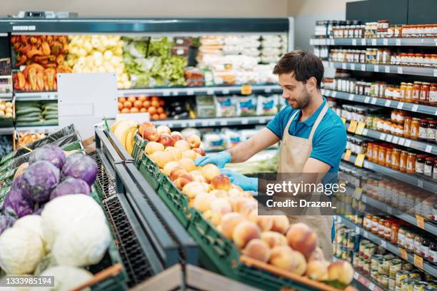 employee in supermarket arranging fresh fruit - arranging products stock pictures, royalty-free photos & images