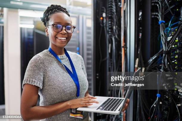 portrait of a young woman using a laptop in a server room - network security stock pictures, royalty-free photos & images