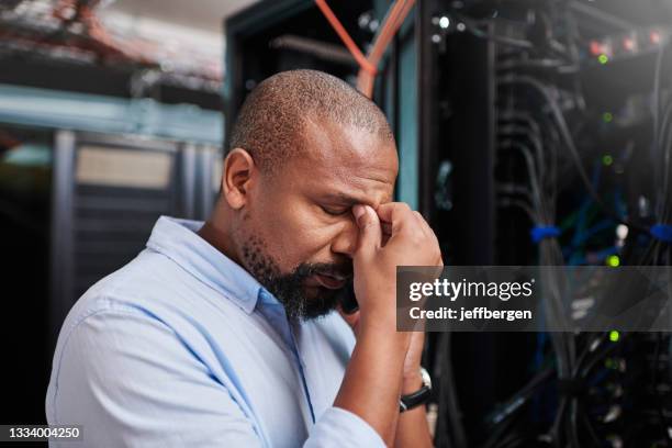 shot of a mature man looking stressed out while working in a server room - tech frustration stock pictures, royalty-free photos & images