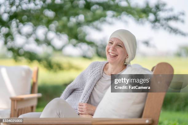 beautiful smiling mature woman with cancer sitting outdoors - head tie stock pictures, royalty-free photos & images