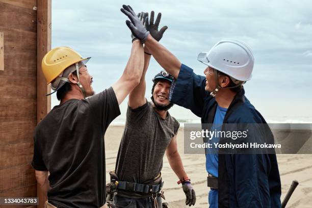 carpenters smile and give high fives - típico de la clase trabajadora fotografías e imágenes de stock