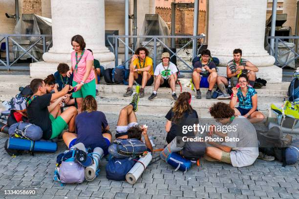 a large group of scouts enjoy a break under bernini's colonnade in st. peter's square in the heart of rome - scout association stock pictures, royalty-free photos & images