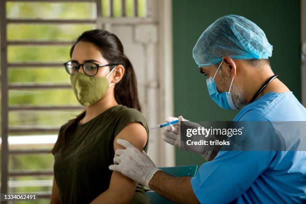 doctor injecting vaccine to female patient - coronavirus india stock pictures, royalty-free photos & images