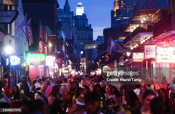 People walk on Bourbon Street in the French Quarter on August 13, 2021 in New Orleans, Louisiana. Louisiana holds one of the nation’s lowest...