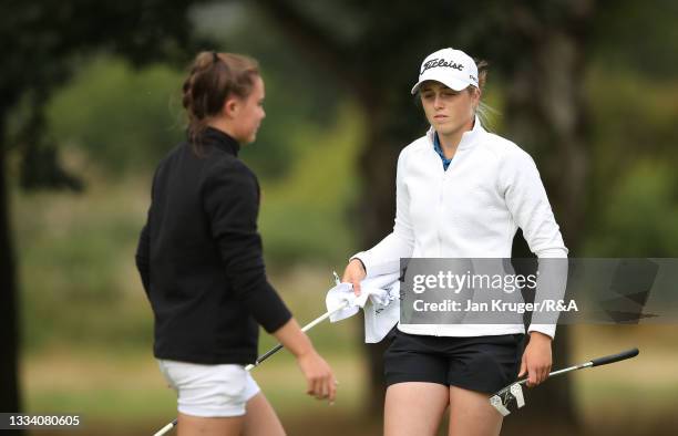 Hannah Darling of Broomieknowe and Beth Coulter of Kirkistown Castle look on after the putting out on the 6th hole during the Final of the R&A Girls...