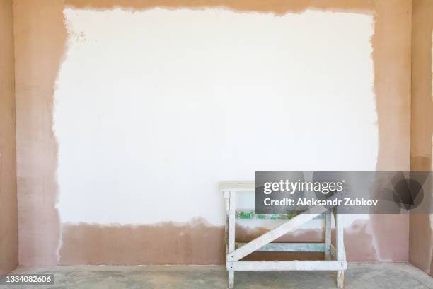 wooden construction ladder or table, on a white wall background. construction of a house. finishing of the apartment, plaster and putty of the walls. the concept of home and professional repair, business and construction industry. a copy of the space. - lime tree stockfoto's en -beelden