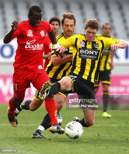 Bruce Djite of Adelaide United and Tony Lochhead of the Wellington Phoenix compete for the ball during the round seven A-League match between the...