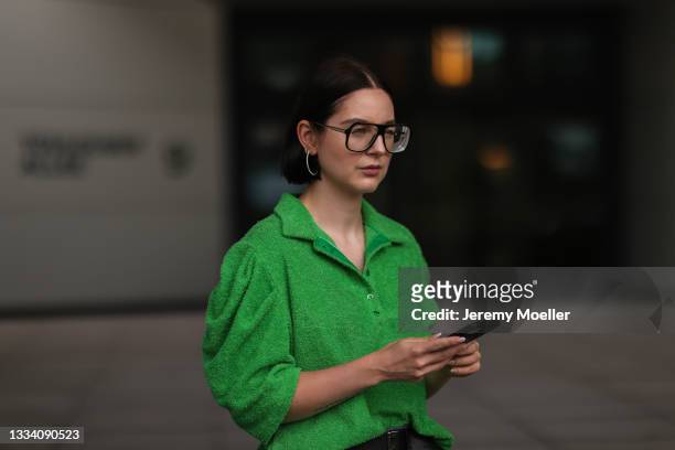Maria Barteczko wearing green terry polo shirt, the Frankie shop leather belt and Victoria Beckham glasses on August 08, 2021 in Dusseldorf, Germany.