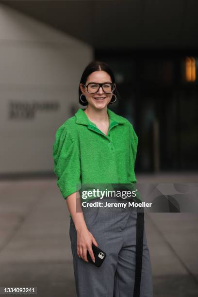 Maria Barteczko wearing green terry polo shirt, Zara grey pants, the Frankie shop leather belt and Victoria Beckham glasses on August 08, 2021 in...