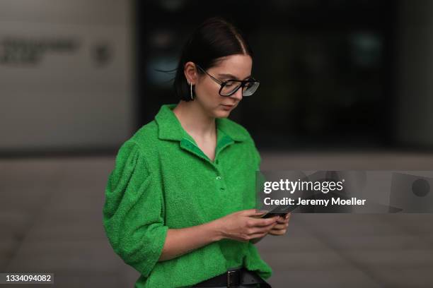 Maria Barteczko wearing green terry polo shirt, the Frankie shop leather belt and Victoria Beckham glasses on August 08, 2021 in Dusseldorf, Germany.