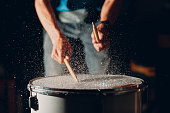 Drum sticks drumming beat rhythm on drum surface with splash water drops