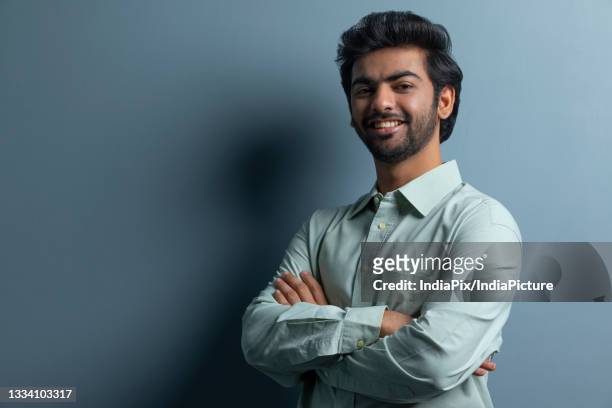 a young executive happily posing in front of camera - green shirt stock pictures, royalty-free photos & images