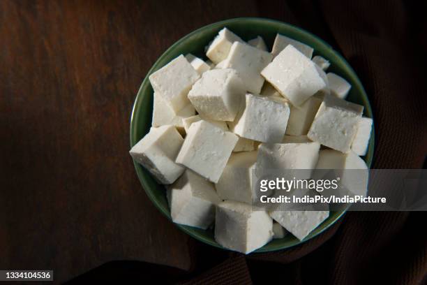 diced paneer or cottage cheese in a green bowl - panir stock pictures, royalty-free photos & images