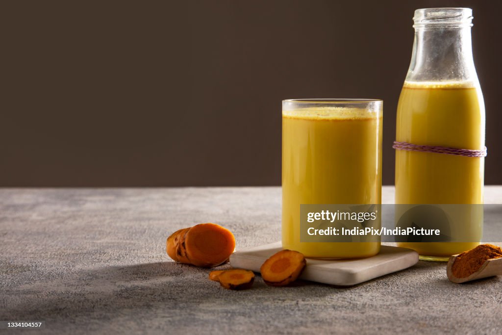 A glass and a bottle of healthy turmeric milk