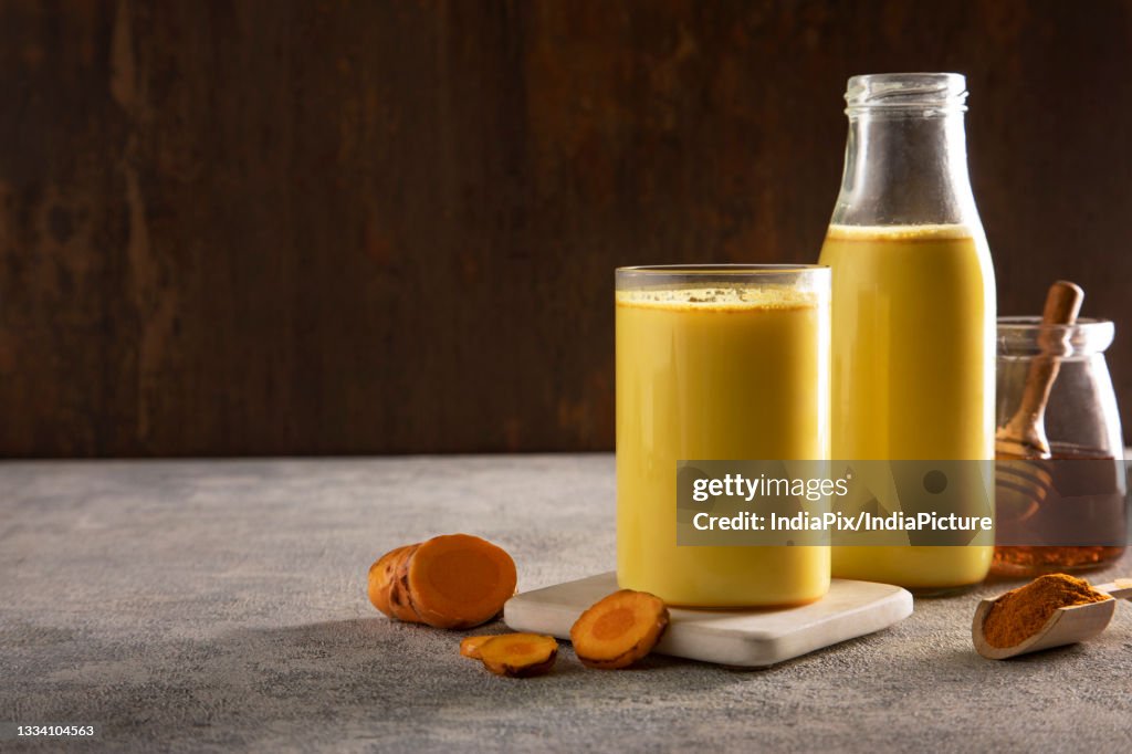 A glass and a bottle of healthy turmeric milk