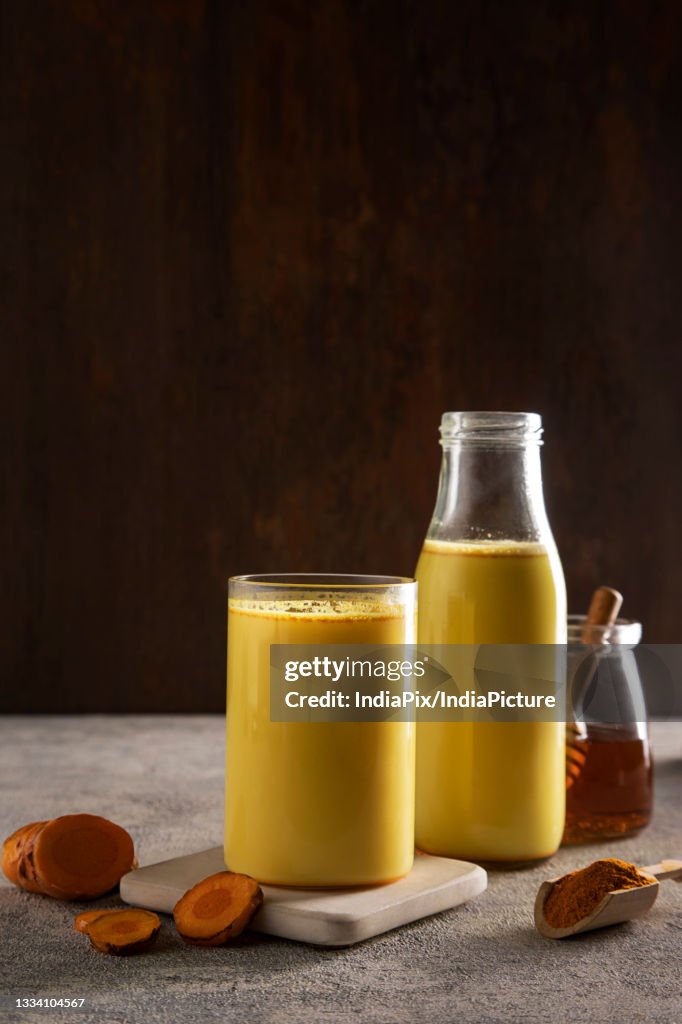 A glass and a bottle of healthy turmeric milk