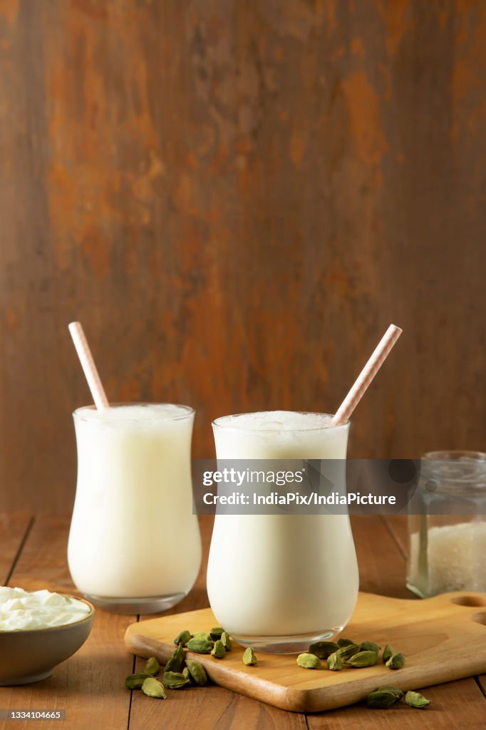 Butter milk in glasses On wooden Table with cardamom