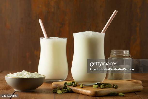 butter milk in glasses on wooden table with cardamom's - lassi stock pictures, royalty-free photos & images