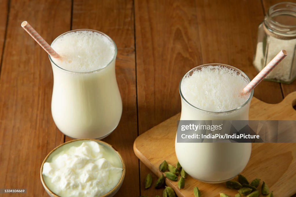 Butter milk in glasses On wooden Table with cardamom's