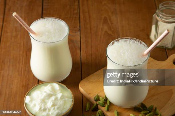 butter milk in glasses on wooden table with cardamom's - lassi stock pictures, royalty-free photos & images