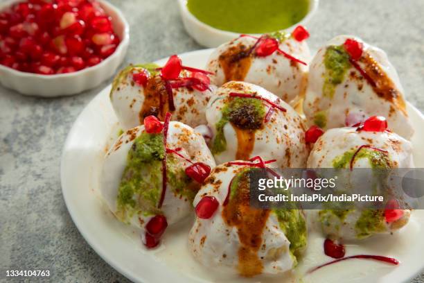 dahi vada or dahi bhalle a popular indian snack is fried lentil dumplings, topped with curd, sweet and green chutney and spices - チャツネ ストックフォトと画像