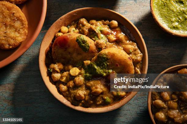 pindi chole curry served hot in a bowl with other food items - aloo tikki stock pictures, royalty-free photos & images