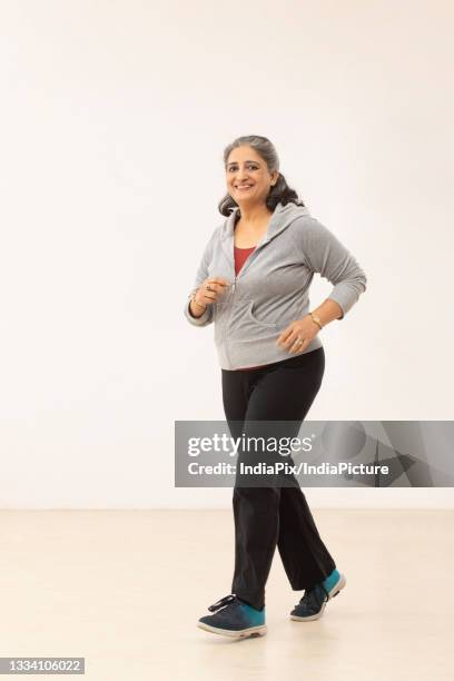 an old woman happily looking straight while walking - 50 year old indian lady stock pictures, royalty-free photos & images