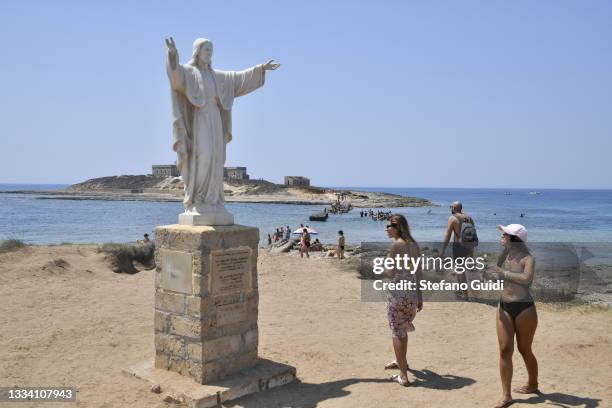 General view of tourists visiting Statue of Christ the Redeemer on August 14, 2021 in Portopalo di Capo Passero, Italy. Capo Passero is the extreme...