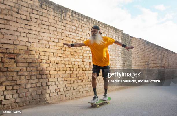 a cheerful old man enjoying skating - young at heart bildbanksfoton och bilder