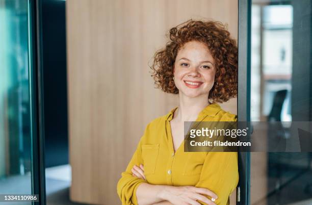 portrait of a smiling young curly woman - alleen jonge vrouwen stockfoto's en -beelden