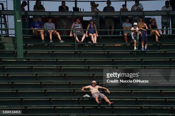 Fans in the center field bleachers trying to stay cool during the fifth inning of a game between the Chicago Cubs and the Milwaukee Brewers at...