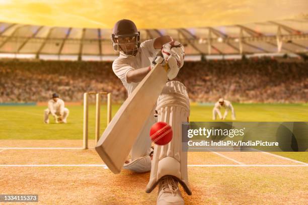 batsman hitting the ball during cricket match in stadium - cricket stumps stock pictures, royalty-free photos & images